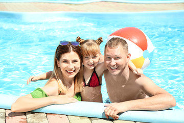 Happy family resting in swimming pool