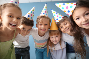 Wall Mural - Cute little children in Birthday hats against color background