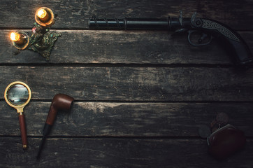 Wall Mural - musket gun, magnifying glass, smoking pipe, wallet and burning candle on wooden table background.