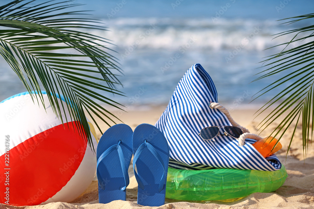 Set of beach items on sand near sea