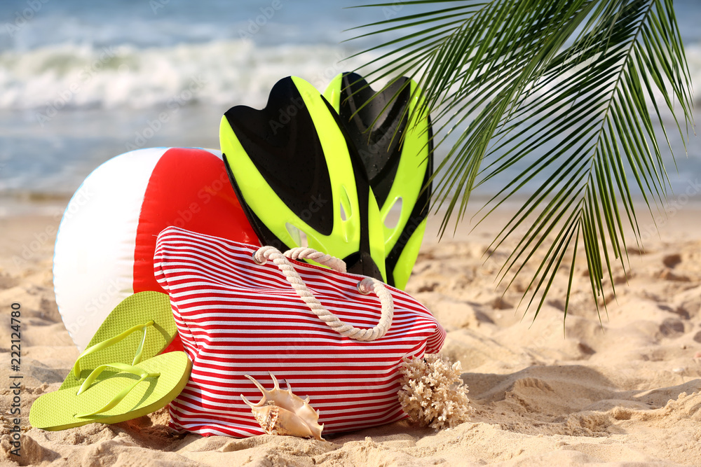 Set of beach items on sand near sea