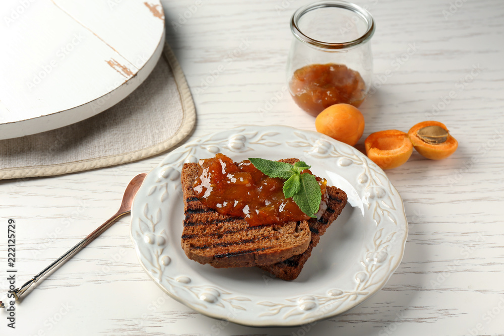 Toasted bread with delicious apricot jam on plate