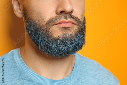 Fotografia Handsome man with dyed beard on color background, closeup