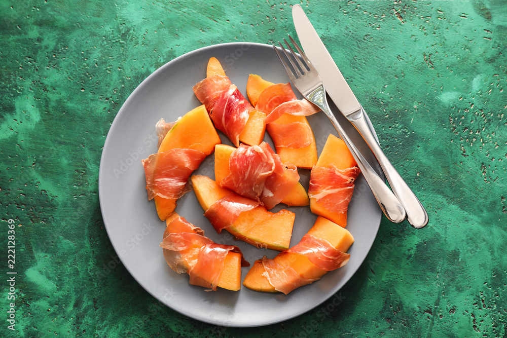 Delicious melon wrapped in prosciutto on plate