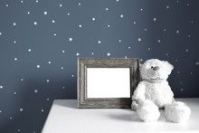 Empty Photo Wooden Frame And White Teddy Bear In The Dark Nursery