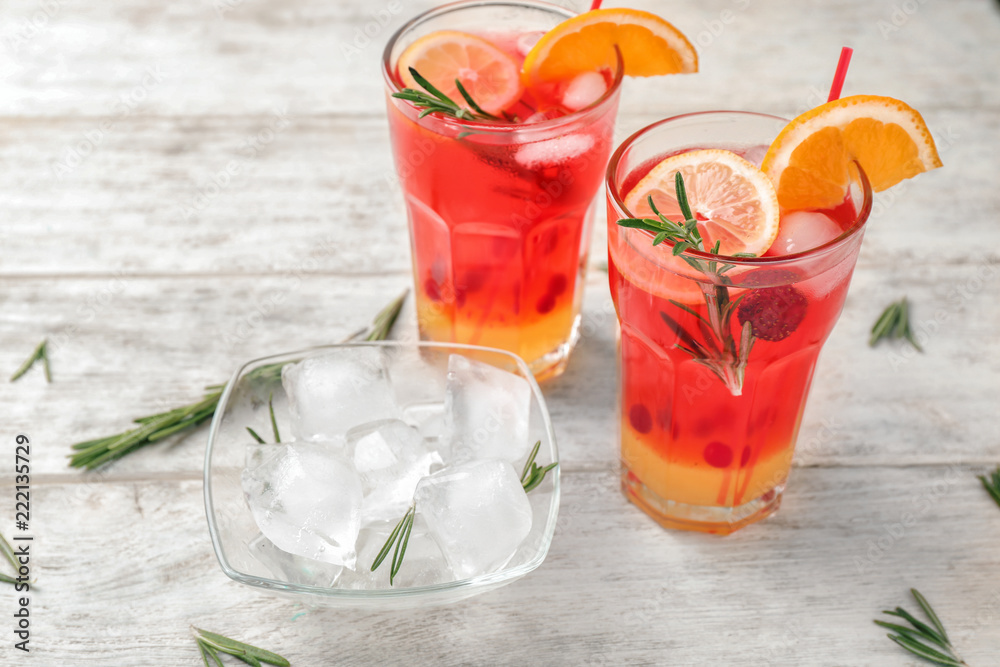 Fresh summer cocktail in glasses with ice on light wooden table