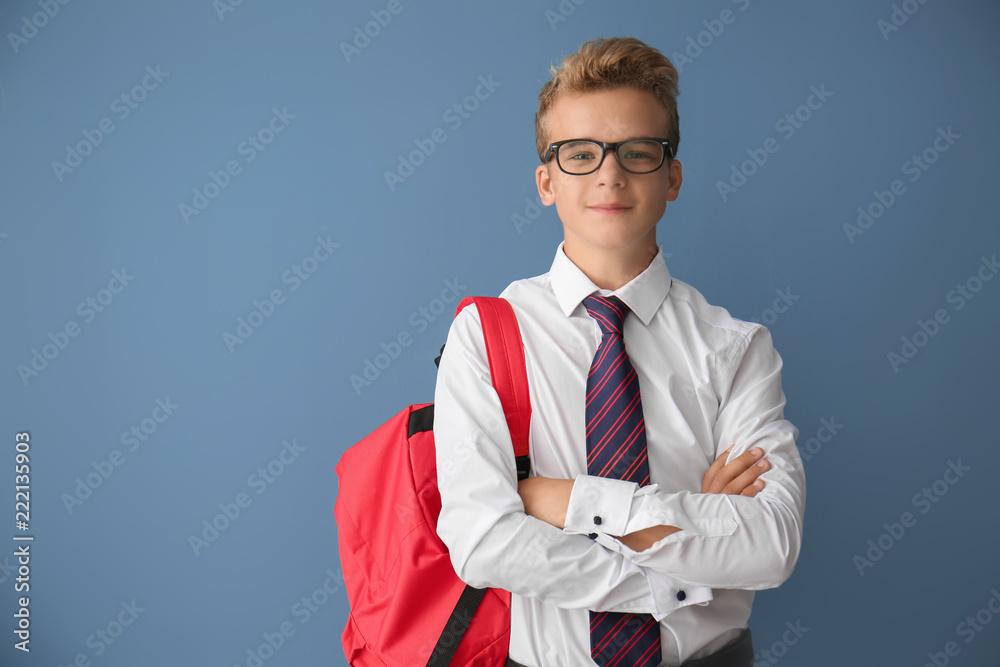 Teenage boy with backpack on color background