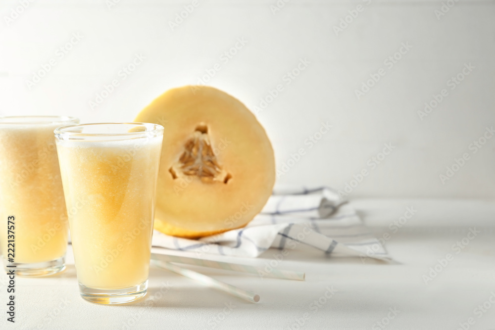 Glasses of delicious melon smoothie on white table