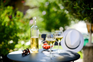 two glass of cool white wine with bottle outdoor in restaurant terrace during a sunny summer day