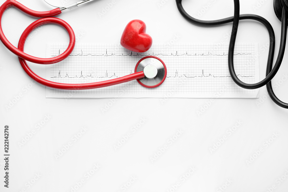 Medical stethoscope, red heart and cardiogram on white background