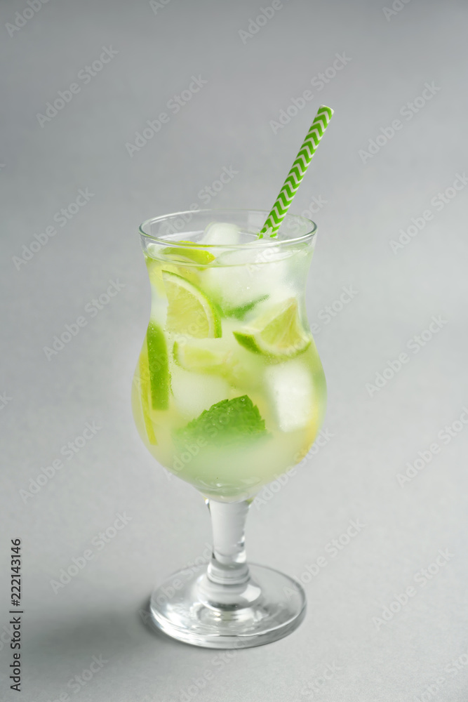 Glass of fresh cocktail on grey background
