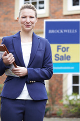 Wall Mural - Portrait Of Female Realtor Standing Outside Residential Property