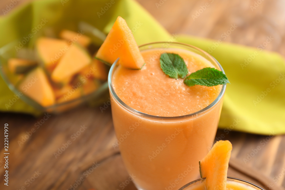 Glass with tasty melon smoothie on wooden table, closeup