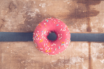 Wall Mural - pink donut on wooden background