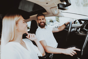 Man Is Driving A Tesla Car. Girl At Front Seat.