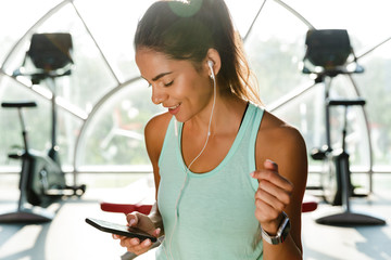 Sticker - Picture of Smiling sports woman in earphones listening music