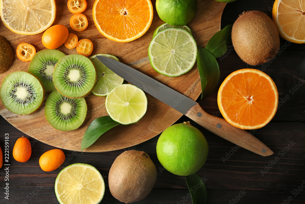 Various delicious exotic fruits with cutting board on wooden background