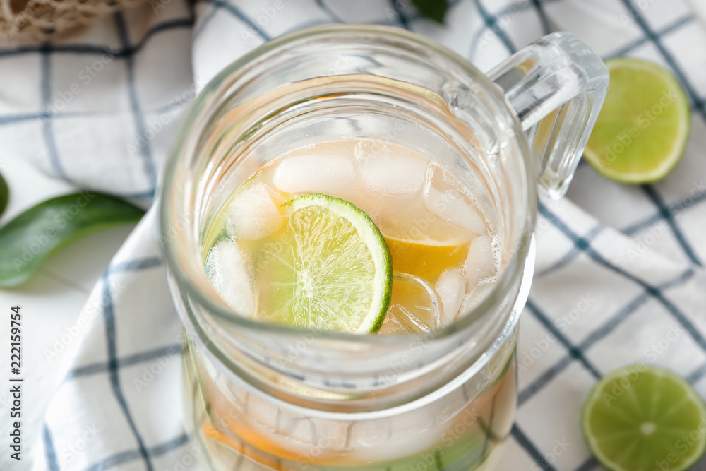 Jug of fresh lime lemonade on table, closeup