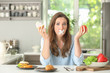 Stressful woman with taped mouth and different products in kitchen. Choice between healthy and unhealthy food
