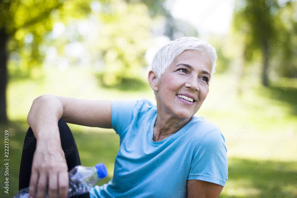 Portrait of smiling senior woman relaxing after exercising - obrazy, fototapety, plakaty 