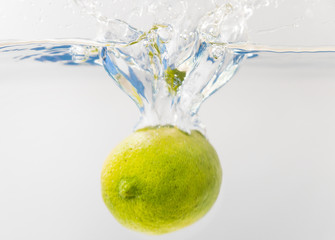 Wall Mural - Fresh lime falling into the water. Suitable for advertisement.