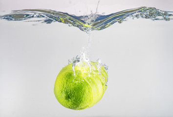 Wall Mural - Fresh lime falling into the water. Suitable for advertisement.