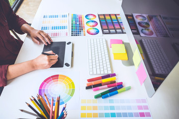 Poster - Image of female creative graphic designer working on color selection and drawing on graphics tablet at workplace