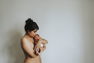 Wall Mural - naked mother holding her infant baby