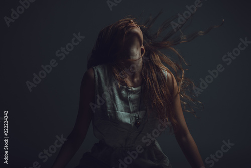 Fotografía Young crazy woman throwing her hair around, expressing agony and pain