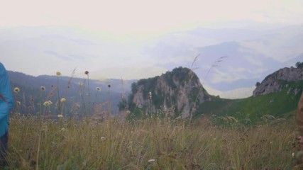 Wall Mural - tourist people walking on meadow while on mountain trip. summer trekking concept