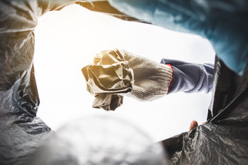 Human hand picking up empty of bottle plastic on park ,volunteer concept