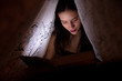© Aleksei Lazukov - young woman reading a book under the covers