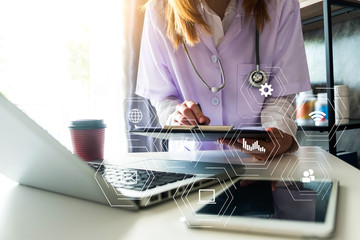 Medical Technology Concepts The doctor is working on a tablet and audio player and a digital tablet computer in a modern office with coffee in the morning at the desk.