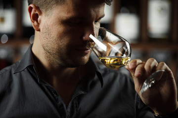 Close up of sommelier man sniffing wine in glass