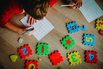 Wall Mural - little boy and girl learn to write and calculate numbers