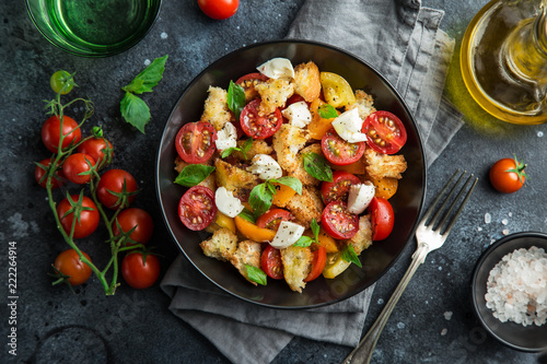 Fotografía panzanella, traditional italian tomato, mozzarella and bread salad in black bowl