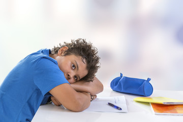 Wall Mural - Overwhelmed schoolboy. Bored and tired teenage boy doing homework on desk in his room,seems sleepinp