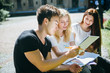 © Мария Кокулина - Group of multi ethnic students study in a city park . Preparing for exam on a fresh air.