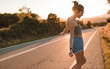 © Angel Ruiz Sanchez - Young girl with hair bun and denim shorts dancing walking and smiling on the edge of the roadway in a sunset of summer