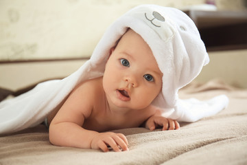 Wall Mural - Cute baby with towel lying on bed at home