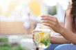 © Pixel-Shot - Young woman with mason jar of fresh lemonade outdoors, closeup