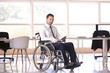 © Pixel-Shot - Businessman in wheelchair working with tablet PC indoors