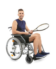 Wall Mural - Sporty young man with tennis racket sitting in wheelchair on white background