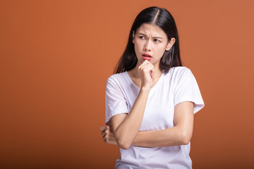 Wall Mural - Thinking woman over orange background.