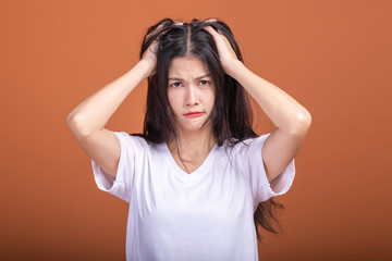 Wall Mural - Thinking woman over orange background.