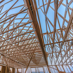 Wall Mural - Looking up at new wood beams building wide angle