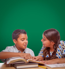 Wall Mural - Blank Chalk Board Behind Hispanic Boy and Girl Having Fun Studying Together