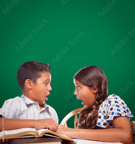 Blank Chalk Board Behind Hispanic Boy and Girl Having Fun Studying Together
