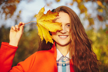 Beautiful young woman with long wavy hair covering face with a l