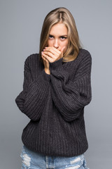 Portrait of a young happy woman in warm winter outfit on gray background